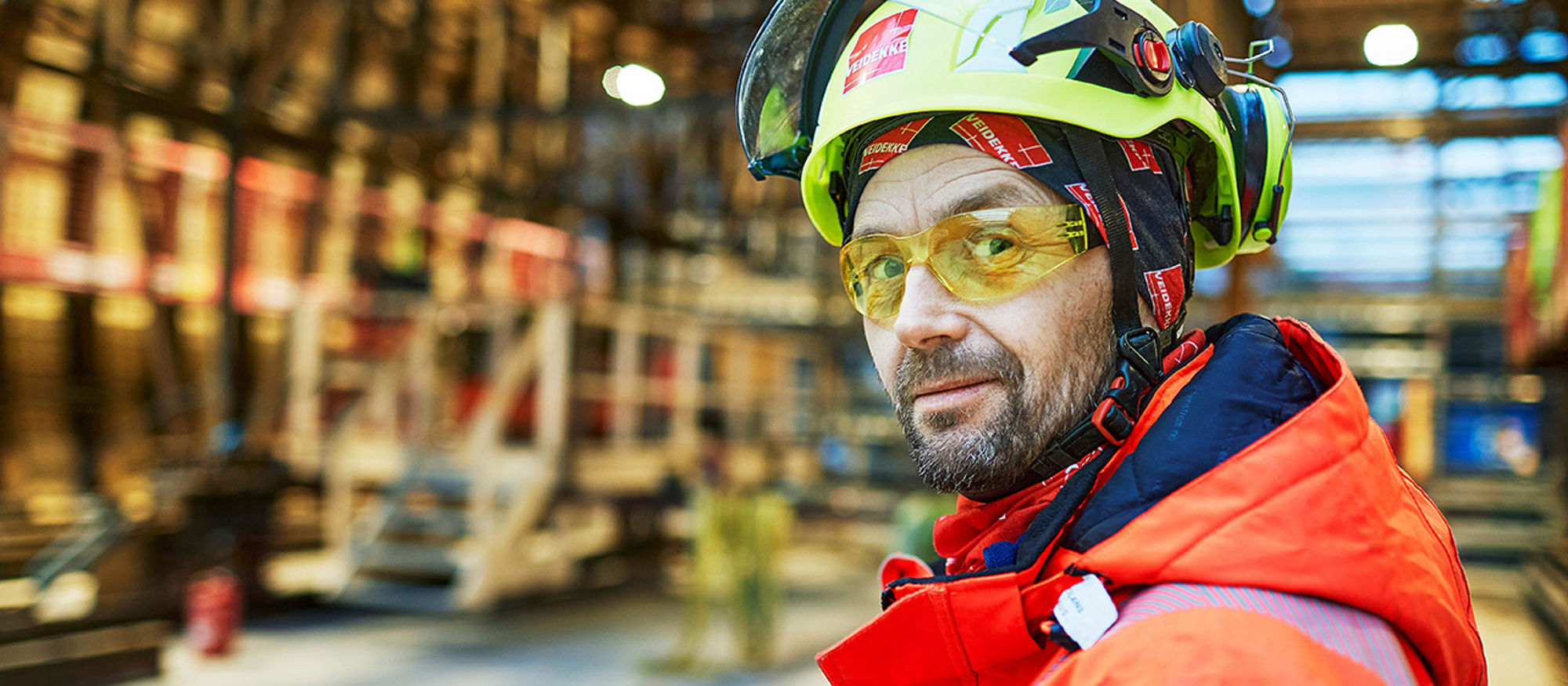 Man on construction site with helmet and visor. Photo.