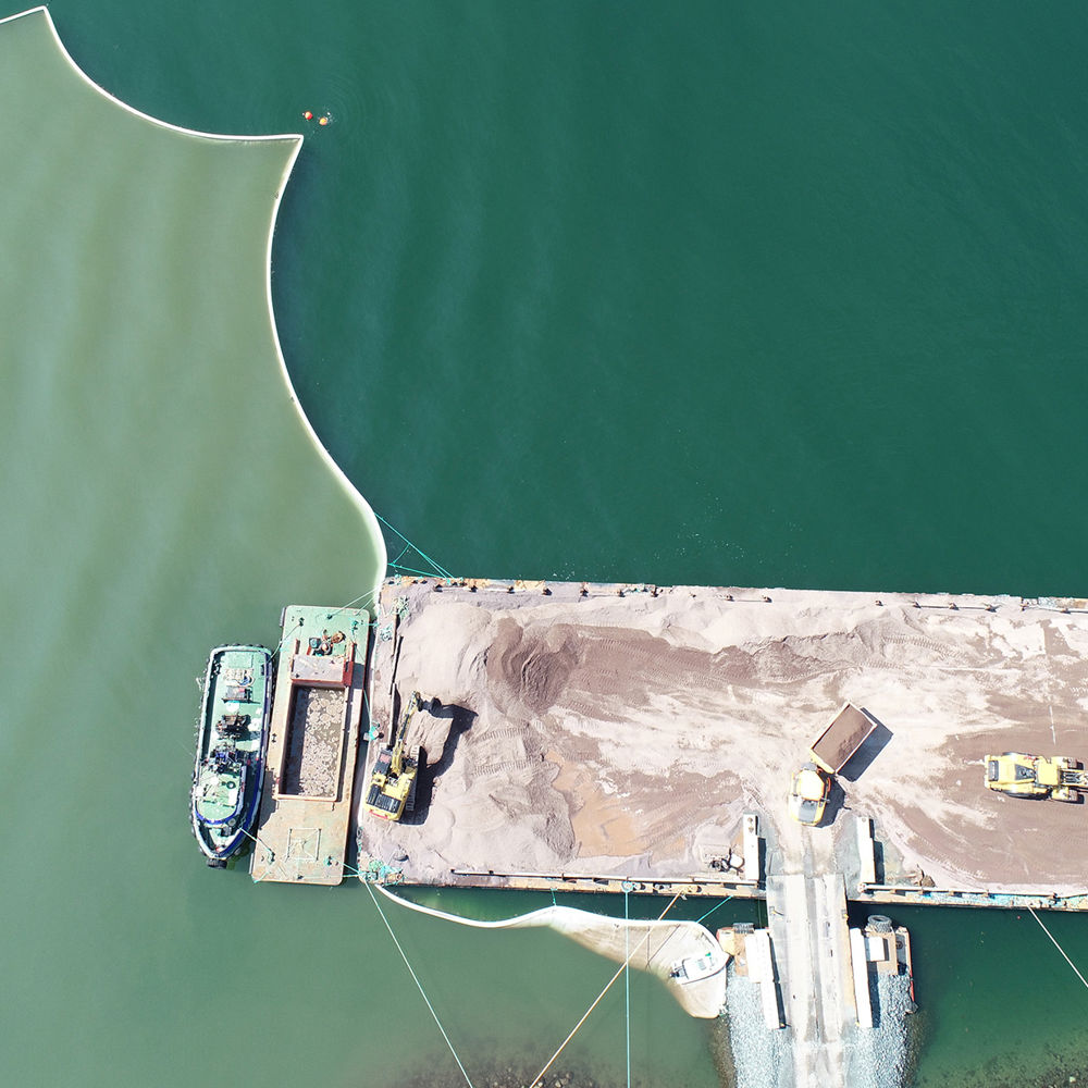 Quay and silt curtain in the ocean. Photo.