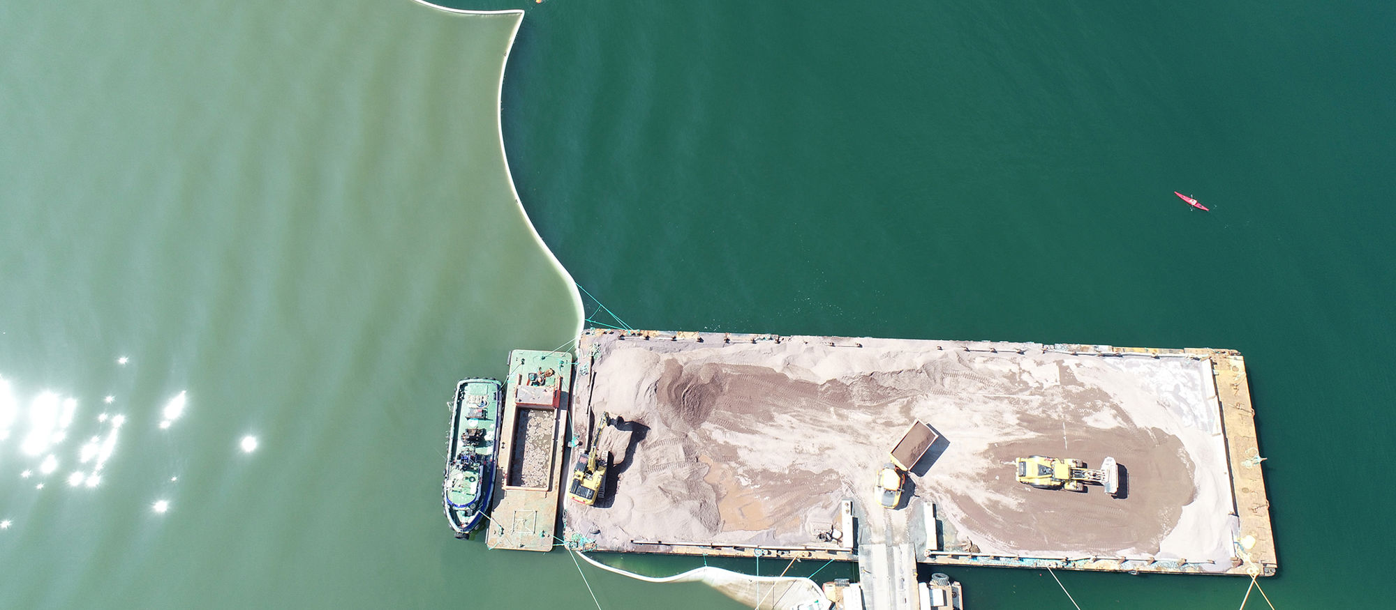 Quay and silt curtain in the ocean. Photo.