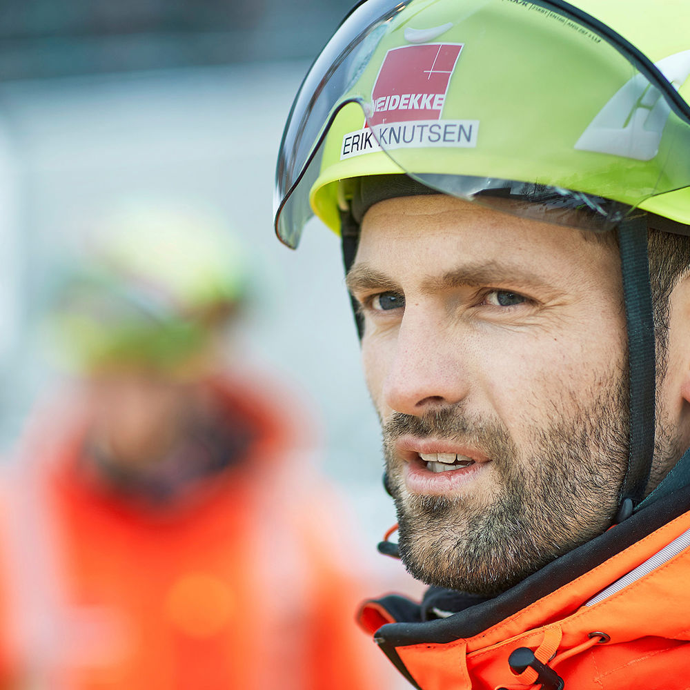 Man wearing yellow helmet looking to the left. Photo.