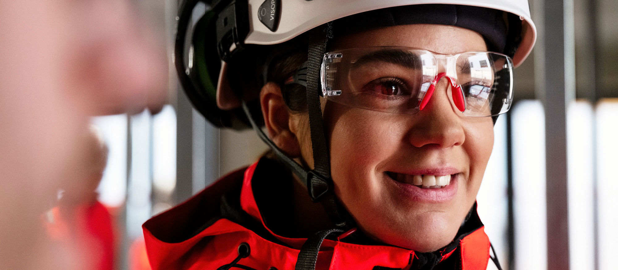 Woman looking at something wearing a helmet at goggles. Photo.