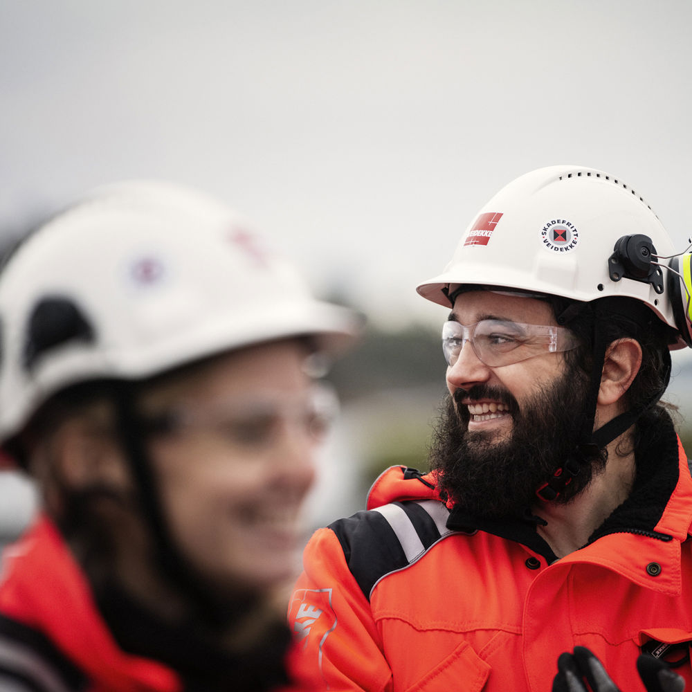 Man and woman wearing high-vis clothing and helmets. Photo.