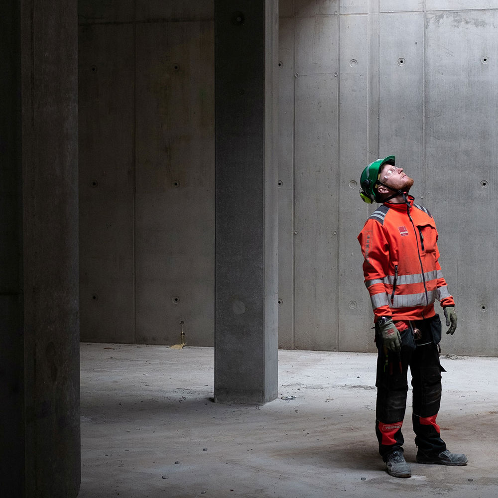 A man i a building with concrete walls. Photo.