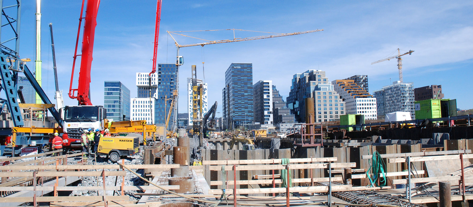 Groundworks with machines and workers. Skyscrapers in the background. Photo.